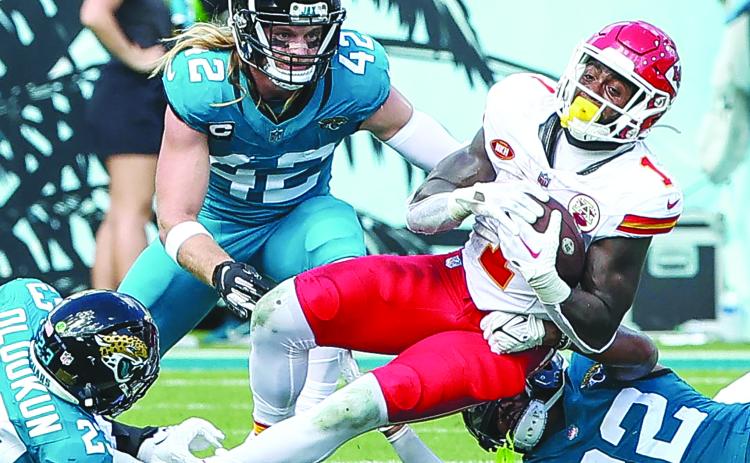 Kansas City’s Jerick McKinnon (1) is taken down by Jacksonville defenders Foyesade Oluokun and Tyson Campbell (32) Saturday at EverBank Field. (JOHN STUDWELL / Special to the Daily News)