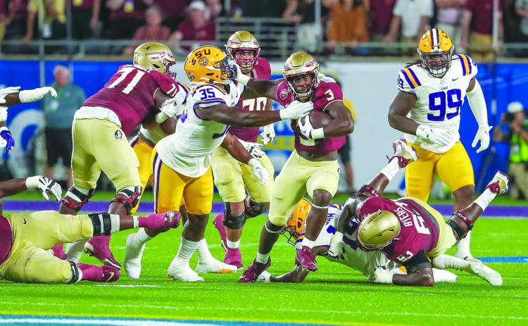 Florida State’s Trey Benson looks to escape the tackle attempt of LSU’s Sai’vion Jones during the Seminoles’ victory in Orlando on Sept. 3. (GREG OYSTER / Special to the Daily News)