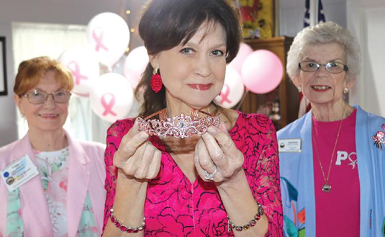 TRISHA MURPHY/Palatka Daily News – News anchor Jeannie Blaylock holds one of the tiaras that were given to breast cancer survivors Monday during a breast cancer awareness event.