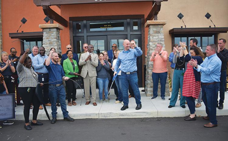 BRANDON D. OLIVER/Palatka Daily News – LongHorn Steakhouse Managing Partner Rob Hull, center, cheers immediately after doing the honors at the restaurant's rope-cutting ceremony Monday afternoon.