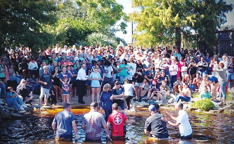 Photo submitted by Ricky Bybee – People gather at the Palatka riverfront Sunday to either cheer on the 160 people getting baptized or prepare to be baptized themselves.