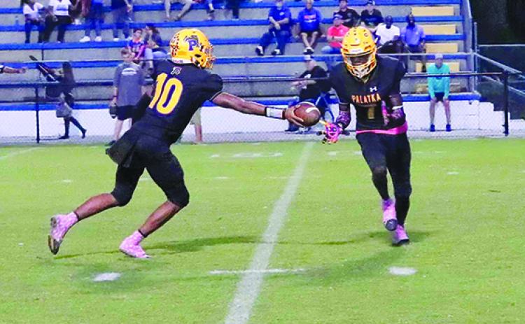 Palatka’s Cartaveon Valentine (right) gets the handoff from quarterback Tommy Offord and goes 22 yards with the first-half play. (RITA FULLERTON / Special to the Daily News)