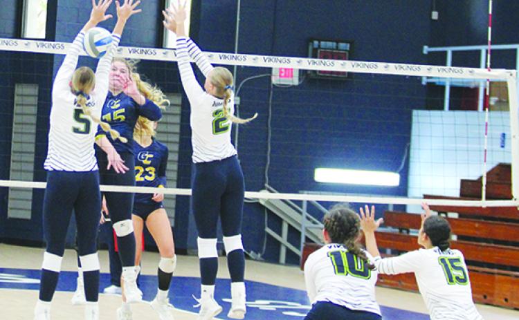 Gulf Coast State’s Annabell Chancy (15) delivers a kill past St. Johns River State’s Gianna San Filippo (5) and Jade Ridgway during Saturday’s match. (MARK BLUMENTHAL / Palatka Daily News)