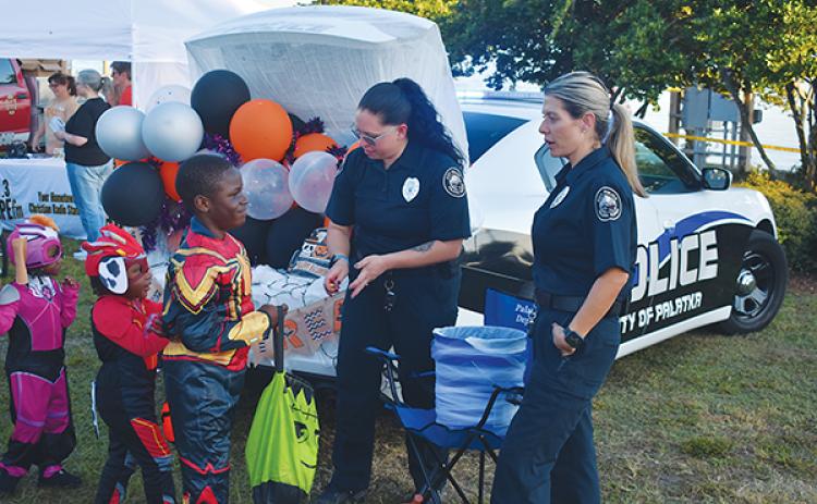 BRANDON D. OLIVER/Palatka Daily News – Costumed children receive candy from Palatka Police Department officers Tuesday during Trunk or Treat at the Palatka riverfront.