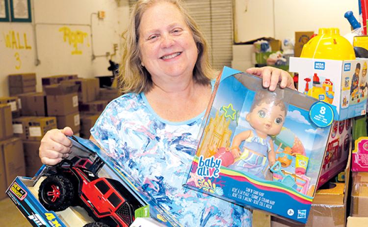 TRISHA MURPHY/Palatka Daily News –  Christi Bellamy, president of the Junior Woman’s Club of Palatka, shows some of the toys Putnam County Elfs for Kids has been collecting to give away this Christmas to children in need. 