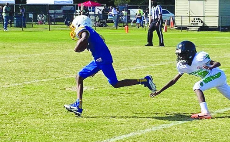 Palatka quarterback Peyton Robinson scampers away from a would-be tackler to score a touchdown on Saturday against the Titletown Titans at William Sheffield Park. The touchdown, though, would be called back due to a penalty. (COREY DAVIS / Palatka Daily News)
