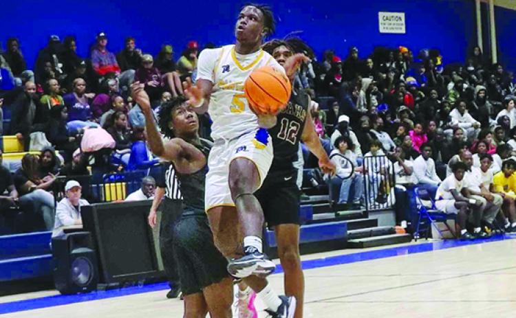 Palatka’s Trenton Williams takes the ball to the basket against St. Augustine’s Dorian Grimes (left) and Peras Lewis during Tuesday night’s game. (RITA FULLERTON / Special to the Daily News)