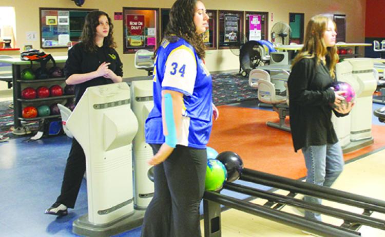 Palatka’s Ashley Griffis (right) gets ready to throw her ball, while teammates Savannah Roberts (left) and Lilly Morgan watch during last Friday’s practice at Putnam Lanes. (MARK BLUMENTHAL / Palatka Daily News)
