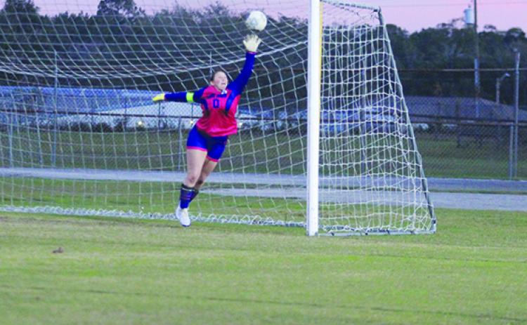 Interlachen girls soccer goalie Paige McCollum goes high for a Marlee Hunt shot in the first half Wednesday night, but the ball goes past her for Fort White’s second goal of the game. (MARK BLUMENTHAL / Palatka Daily News)