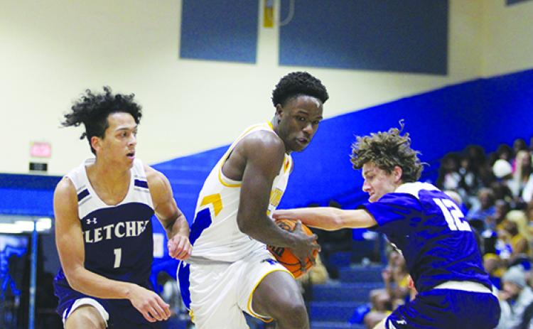 Palatka’s Trenton Williams (middle) looks to take the ball to the basket while guarded by Neptune Beach Fletcher’s Anthony Vaglienti (1) and Sam Perry during Wednesday’s game in the Jarvis Williams Holiday Classic. (MARK BLUMENTHAL / Palatka Daily News)
