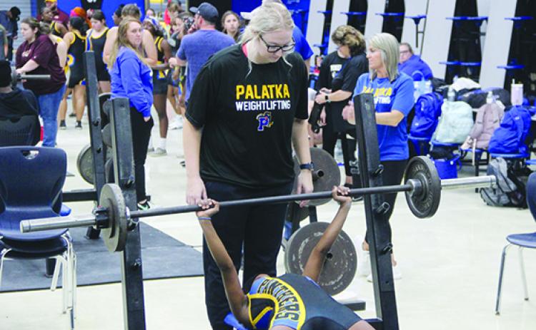 With her head coach, Katelynn Smith, spotting her, Palatka’s Ymira Passmore competes in the bench press at 101 pounds Wednesday. (COREY DAVIS / Palatka Daily News)
