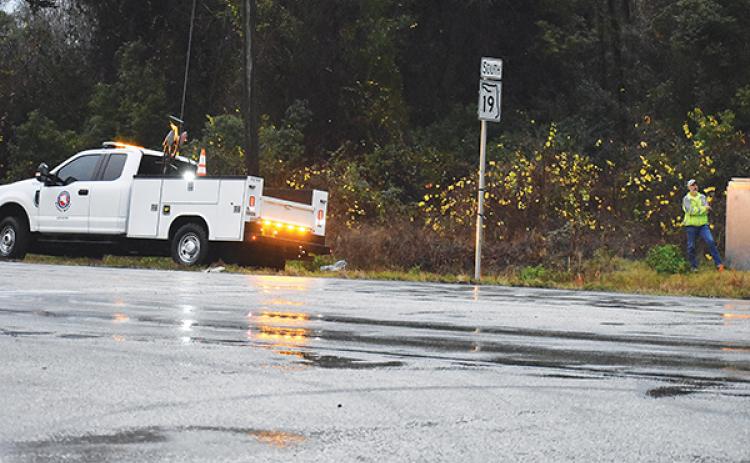 BRANDON D. OLIVER/Palatka Daily News – A Putnam County employee works on equipment at the intersection of State Road 19 and Silver Lake Drive on Tuesday during the storm that pounded the area with rain.
