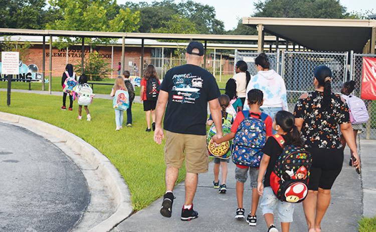 File photo. Parents and children head into William D. Moseley Elementary School on the first day of school in 2023. 