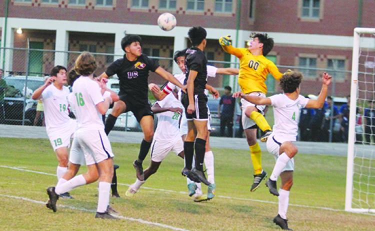 Father Lopez High School boys soccer goalkeeper Leo Spears (00) knocks the ball away from a headball attempt by Crescent City’s Bryan Garcia (16) during Thursday’s game. (MARK BLUMENTHAL / Palatka Daily News)