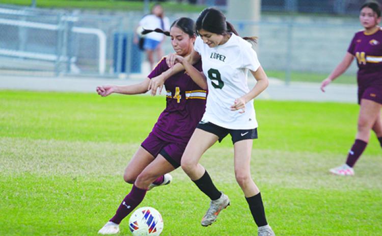 Crescent City’s Abigail Medina (left) and Daytona Beach Father Lopez’s Barbara Arreola go after a loose ball Friday night in the District 9-3A girls soccer semifinals. (MARK BLUMENTHAL / Palatka Daily News)