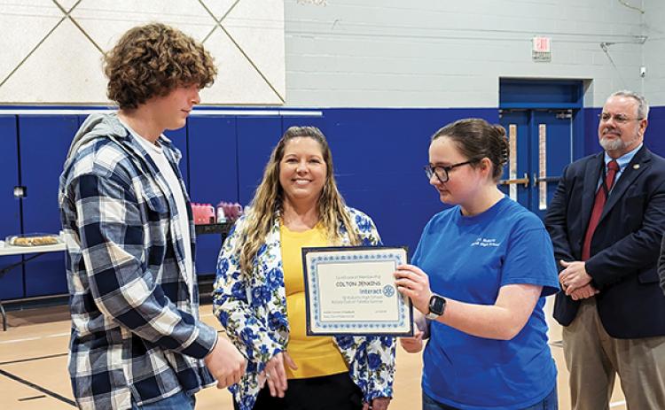 Photo submitted by Doug Thompson – Reagan Blackmer, right, hands Colton Jenkins his certificate Thursday during the Interact induction ceremony at Q.I. Roberts Junior-Senior High School in Florahome.