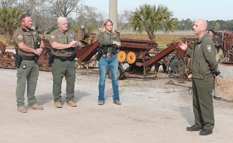 Photo courtesy of the Putnam County Sheriff’s Office – Putnam County Sheriff’s Office Col. Joe Wells speaks to Putnam deputy Sara Werninck and St. Johns County Sheriff’s Office deputies Jerry Gentry and Michael Pedonti at Bulls Hit Farm in Hastings before they are sworn in to work agriculture cases in both counties.