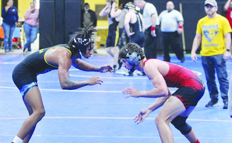 Palatka's Ishmael Foster (left) does battle with Baker County's Tax Kinghorn during the District 4-1A 132-pound championship. In the background at right is Palatka head coach Josh White. (MARK BLUMENTHAL / Palatka Daily News)