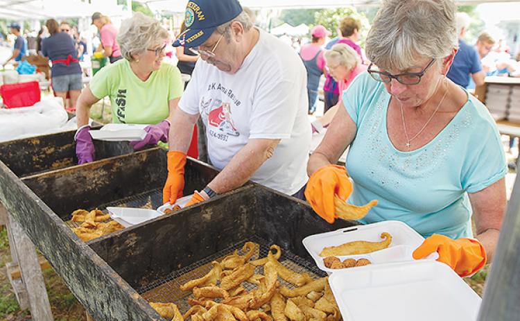 File photo – Volunteers prepare dinner plates at a previous Crescent City Catfish Festival.