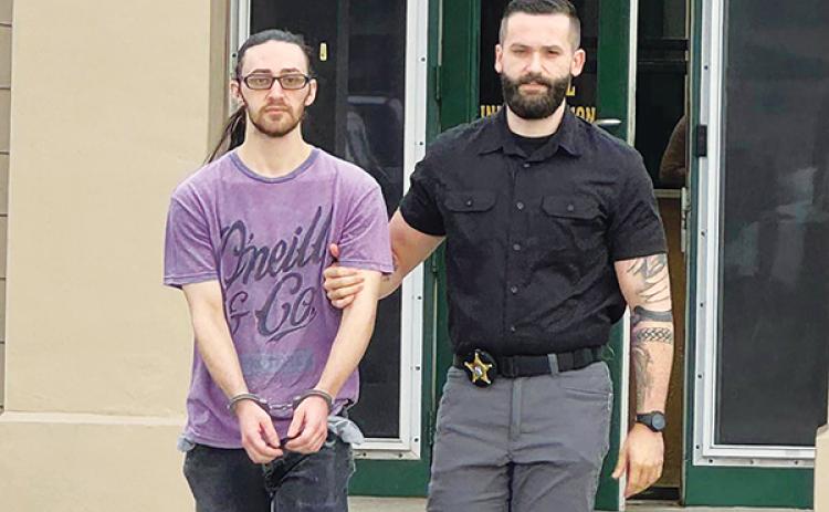 Photo courtesy of the Putnam County Sheriff's Office – A Putnam County Sheriff's Office detective walks suspect Dalton Richard Babcock to be booked into the jail earlier this month.
