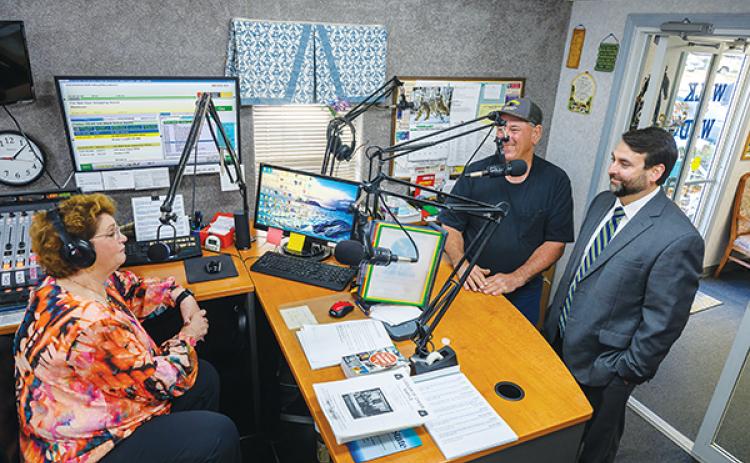 Photos submitted by Peter Willott WPLK/WIYD – Station Manager Susan Player, left, talks to former station owner Skeet Alford, center, and new owner Charlie Douglas, right, talk after the station changed hands Tuesday.