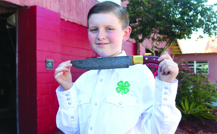TRISHA MURPHY/Palatka Daily News. Liam Rawls, 9, of Palatka won Best of Show for his forged knife that he entered in competition through his 4-H Club at this year’s Putnam County Fair. He said his forged knife is made of Damascus steel and sports a 10-inch blade with a five-inch wooden handle with a unique blade design.