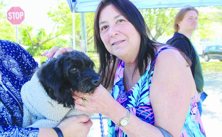 St. Augustine resident Mindy Esbin shows her new dog, Sadie, some love Friday during an adoption event where 41 dogs found new homes. (SARAH CAVACINI / Palatka Daily News)