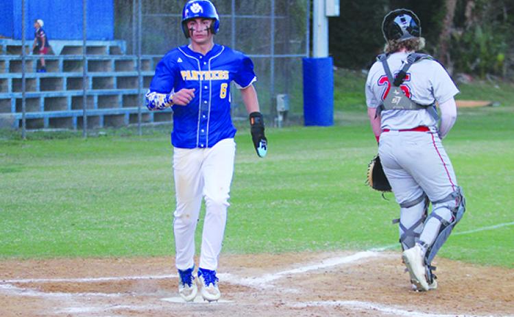 Palatka’s Jace Akers steps on home plate to score a fifth-inning run against Alachua Santa Fe behind Raiders catcher Tyler Whitworth. (MARK BLUMENTHAL / Palatka Daily News)