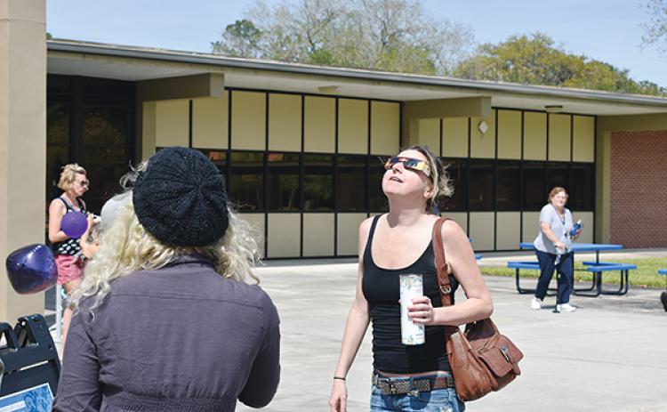 BRANDON D. OLIVER/Palatka Daily News – A woman takes in the solar eclipse Monday during a viewing party at St. Johns River State College in Palatka.