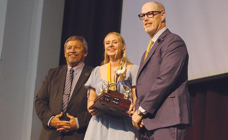 SARAH CAVACINI/Palatka Daily News – Crescent City Junior-Senior High School student Emme Delaney, center, stands with Superintendent Rick Surrency, left, and presenter Douglas Webb after receiving the Robert W. Webb Award of Excellence during Tuesday’s Top Scholar Awards Ceremony.
