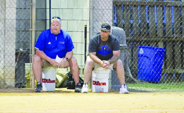 Peniel Baptist Academy softball coach Jeff Hutchins (left) and new assistant coach Brandon Zurn watch over the Warriors in their 13-3 victory over Gainesville Countryside Christian March 7 at Rotary Park. (MARK BLUMENTHAL / Palatka Daily News)