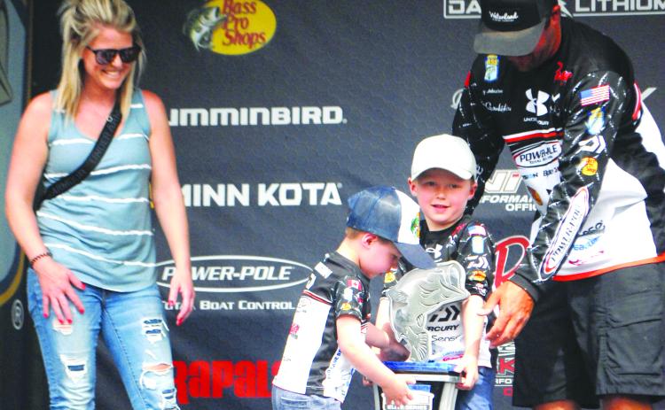 With wife Kerrilee Johnston looking on, sons Luke, 3, and Jack, 5, try to lift the MAXAM Tire Bassmaster Elite at the St. Johns River trophy won by their father, Cory Johnston, on Sunday. (GREG WALKER / Daily News correspondent)