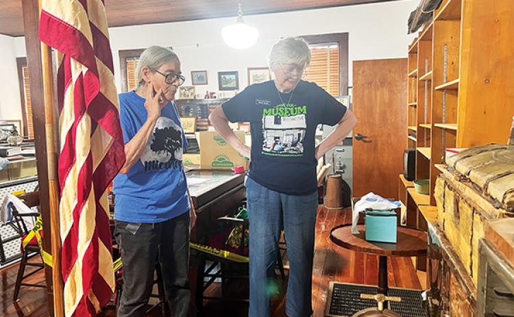 SARAH CAVACINI/Palatka Daily News – Historical Society of Interlachen President Pat High and Secretary Sharon Varnes discuss what to do with an old printing press in Interlachen Hall on Friday while packing up to vacate the building.